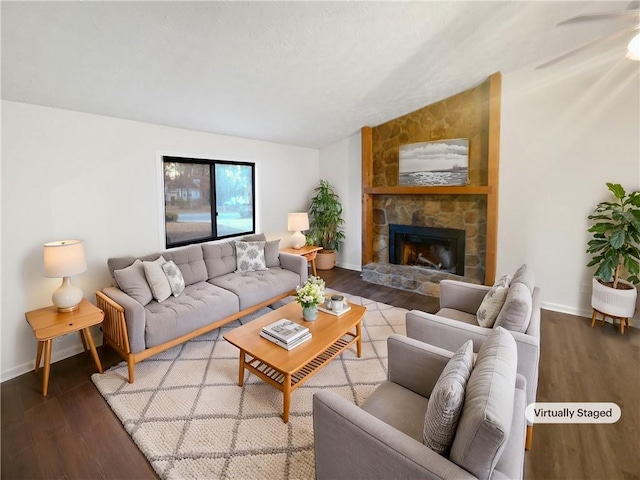 living room featuring vaulted ceiling, a fireplace, wood finished floors, and baseboards