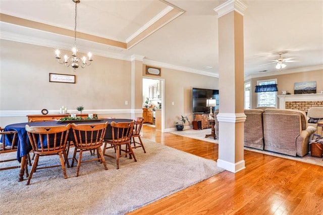 dining room with decorative columns, crown molding, ceiling fan, and light hardwood / wood-style flooring