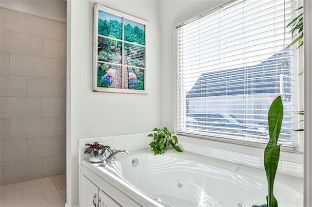 bathroom featuring a relaxing tiled tub and tile patterned flooring