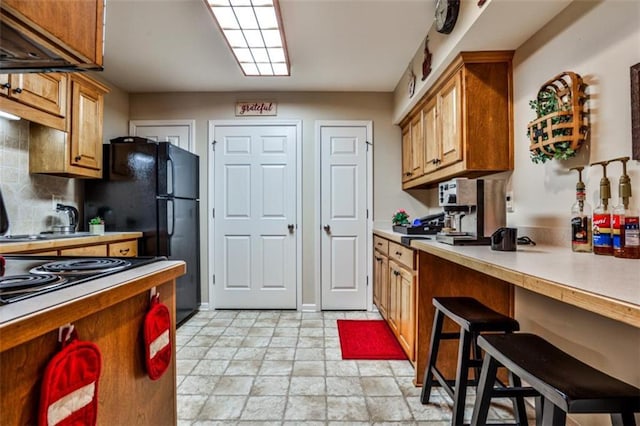 kitchen with a breakfast bar and backsplash