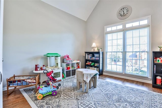 game room with hardwood / wood-style floors and vaulted ceiling