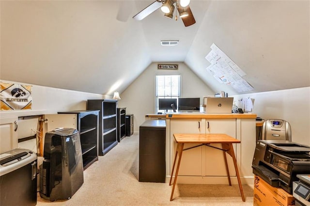 carpeted office space featuring vaulted ceiling and ceiling fan