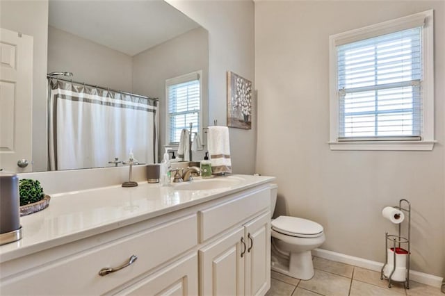 bathroom featuring vanity, plenty of natural light, tile patterned floors, and toilet