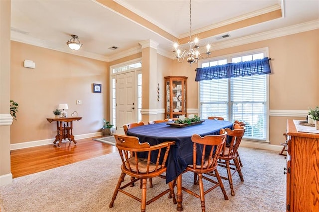 dining room with ornate columns, crown molding, an inviting chandelier, and a tray ceiling