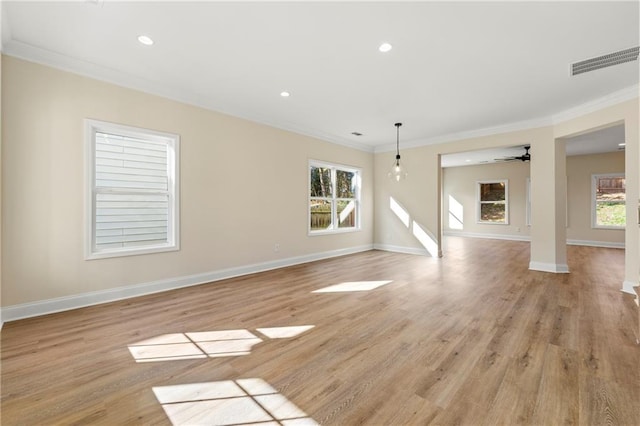 unfurnished living room with ornamental molding, light hardwood / wood-style floors, ceiling fan, and a healthy amount of sunlight