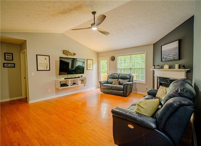 1444 Elliotts Ln, Auburn, GA 30011 - living room featuring a textured ceiling, a ceiling fan, wood finished floors, lofted ceiling, and a fireplace