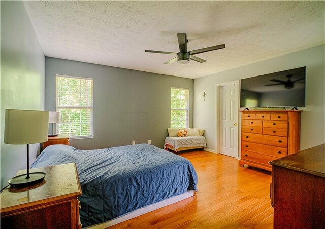 1444 Elliotts Ln, Auburn, GA 30011 - bedroom with light wood-style floors, multiple windows, a ceiling fan, and a textured ceiling