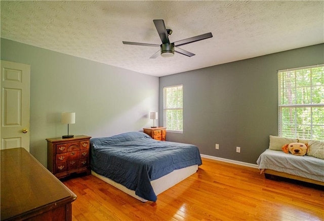 1444 Elliotts Ln, Auburn, GA 30011 - bedroom featuring wood finished floors, baseboards, a textured ceiling, and ceiling fan