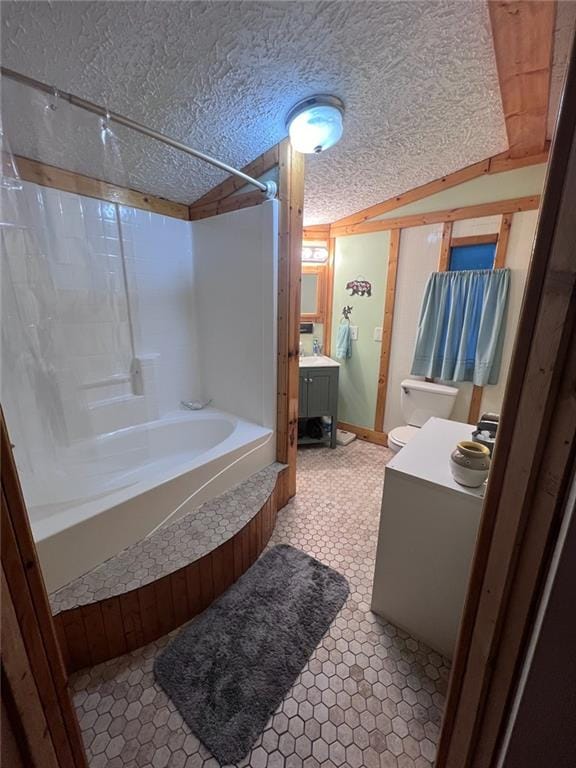 bathroom with a textured ceiling, washtub / shower combination, vanity, and vaulted ceiling