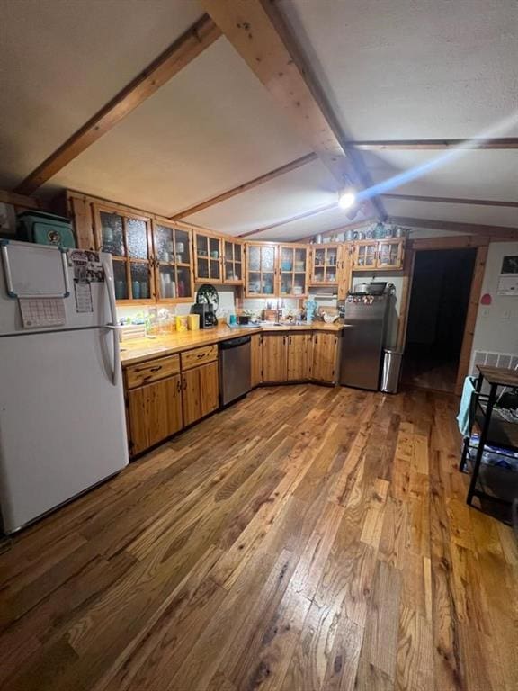 kitchen with light wood-type flooring, lofted ceiling with beams, and stainless steel appliances