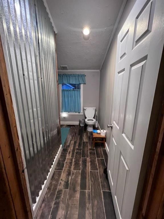 corridor featuring dark hardwood / wood-style floors and crown molding