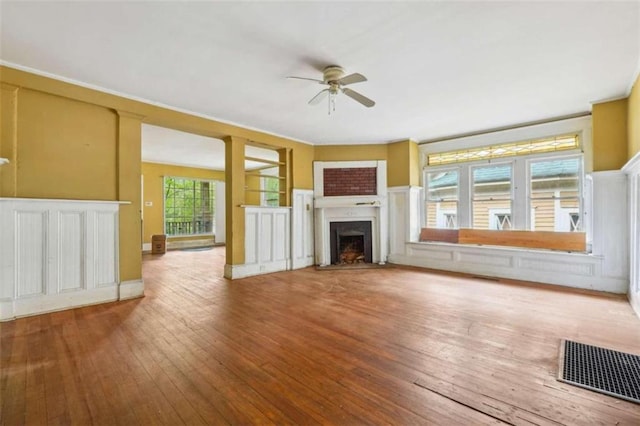 unfurnished living room with wood-type flooring, plenty of natural light, and ceiling fan