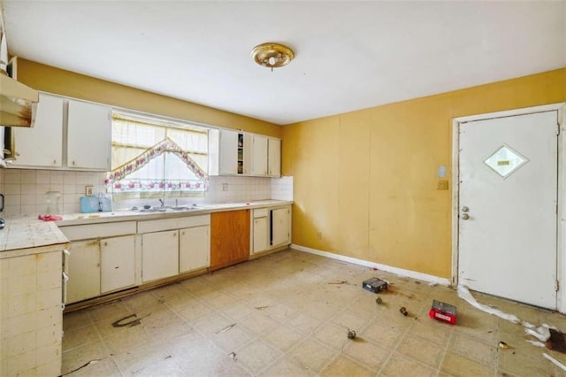 kitchen with white cabinets, sink, and tasteful backsplash