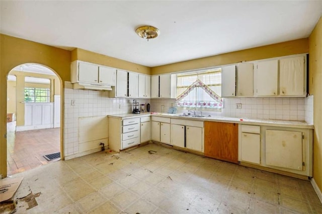 kitchen with decorative backsplash, cream cabinets, and sink