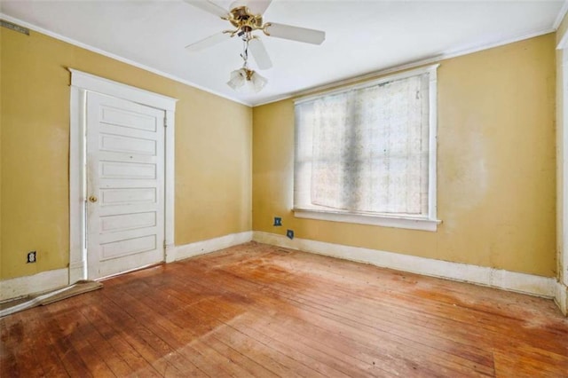 spare room with wood-type flooring, ceiling fan, and ornamental molding