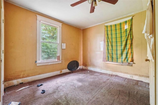 carpeted empty room with ceiling fan and crown molding