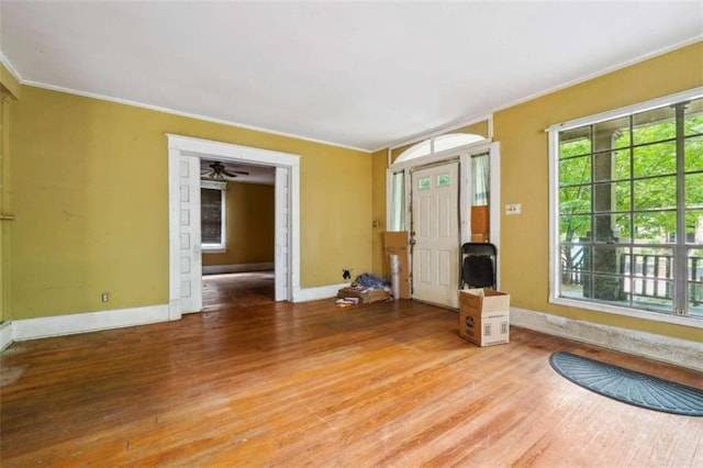 unfurnished living room featuring hardwood / wood-style floors and crown molding