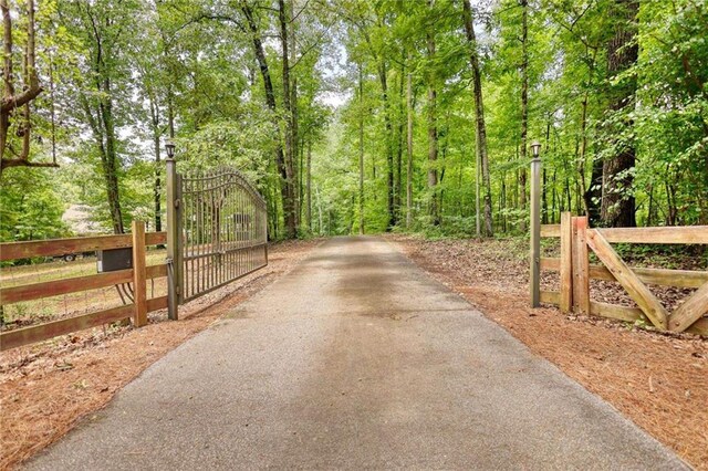 116 Woolsey Creek Trl, Fayetteville, GA 30215 - view of asphalt driveway featuring a gate and a wooded view