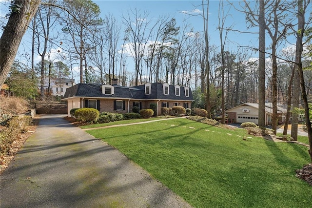 view of front facade featuring an outbuilding, a garage, and a front yard