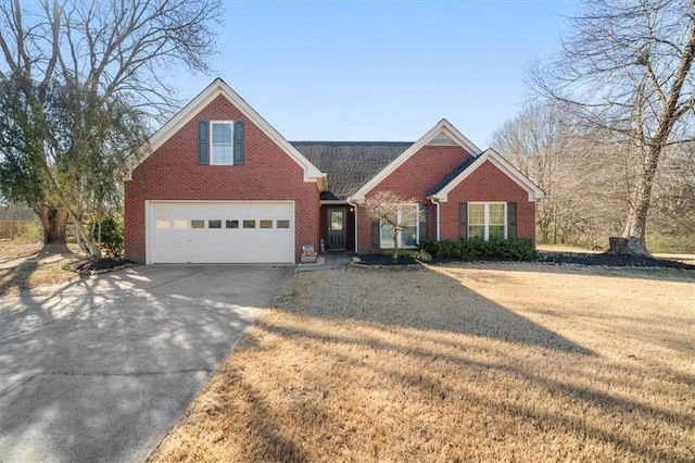 traditional-style home with a front yard, concrete driveway, brick siding, and an attached garage