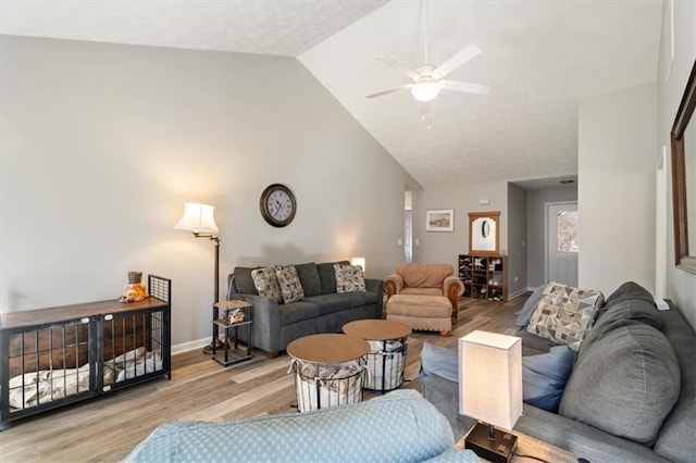 living room with high vaulted ceiling, a ceiling fan, baseboards, and wood finished floors