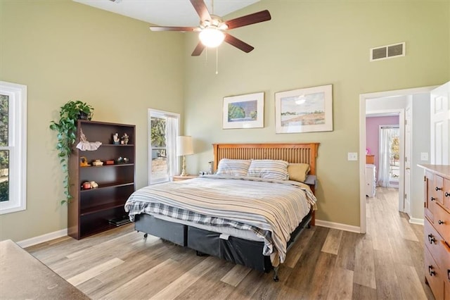 bedroom featuring multiple windows, visible vents, and light wood-style floors