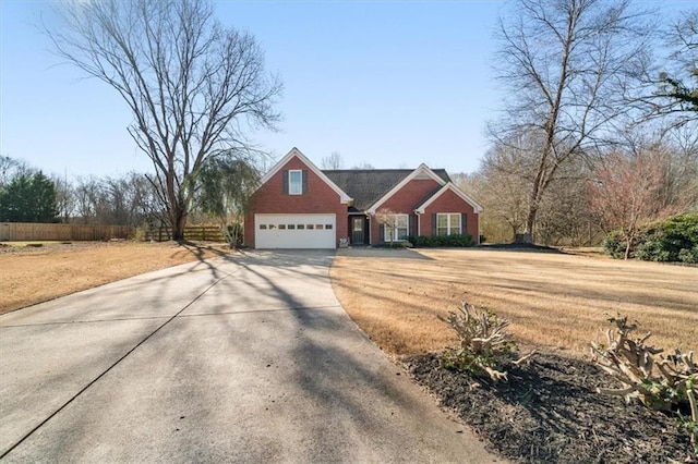 view of front of house featuring a front yard, concrete driveway, fence, and an attached garage