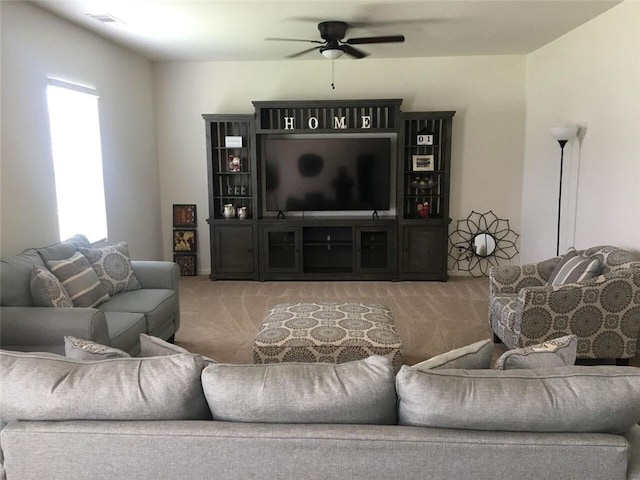 carpeted living room with a healthy amount of sunlight and ceiling fan