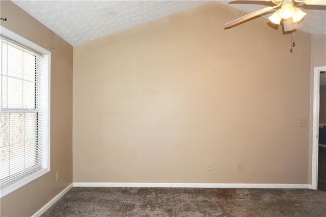 carpeted empty room with ceiling fan, vaulted ceiling, and a textured ceiling