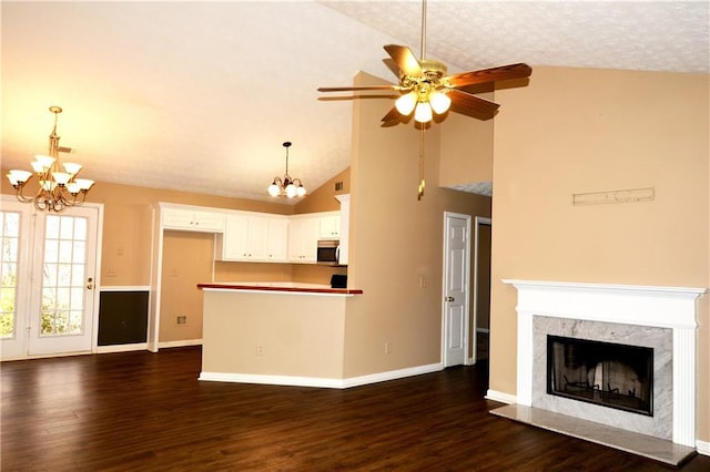 unfurnished living room with high vaulted ceiling, a premium fireplace, dark hardwood / wood-style floors, and ceiling fan with notable chandelier