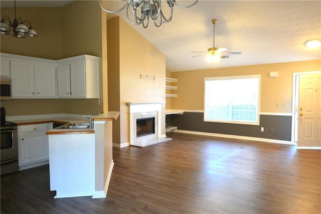 kitchen with sink, dark wood-type flooring, appliances with stainless steel finishes, white cabinets, and kitchen peninsula