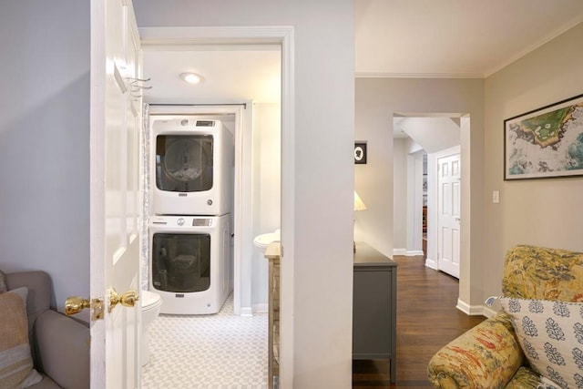 2195 Edison Ave NE, Atlanta, GA 30305 - laundry room featuring baseboards, crown molding, stacked washer and clothes dryer, dark wood-type flooring, and laundry area