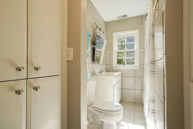 2195 Edison Ave NE, Atlanta, GA 30305 - bathroom featuring toilet, tile patterned floors, tile walls, visible vents, and vanity