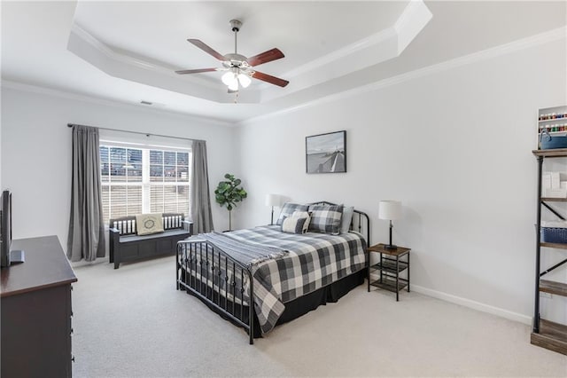 bedroom with a raised ceiling, crown molding, and light colored carpet