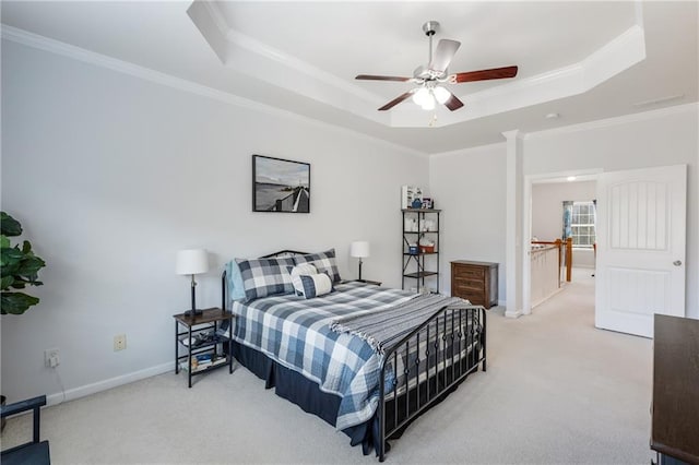 bedroom featuring a tray ceiling, baseboards, carpet floors, and ornamental molding