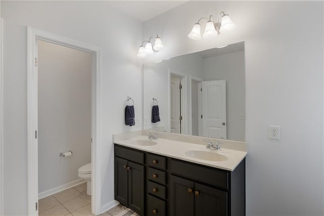 bathroom featuring a sink, toilet, double vanity, and tile patterned flooring