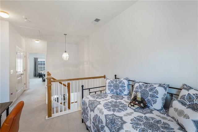 bedroom with attic access, visible vents, and carpet floors