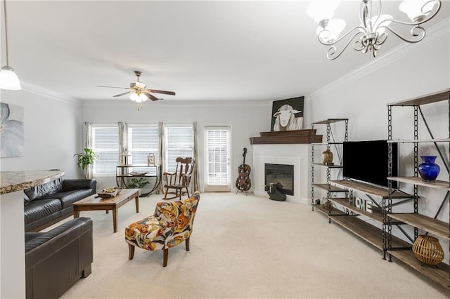 living area with a glass covered fireplace, ceiling fan with notable chandelier, carpet, and ornamental molding