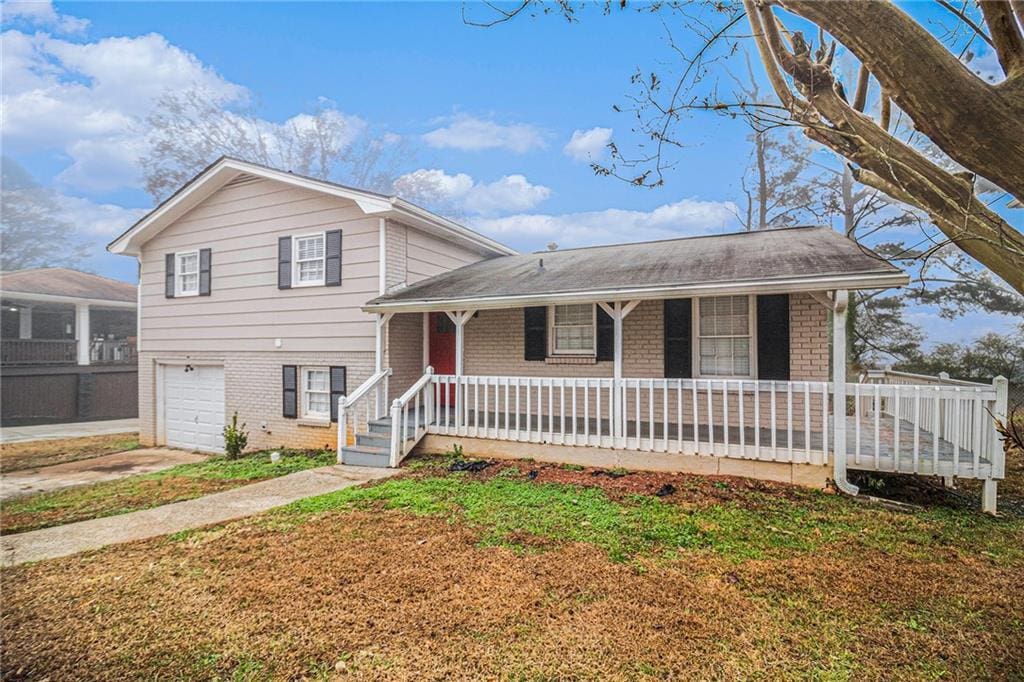 tri-level home featuring covered porch and a garage