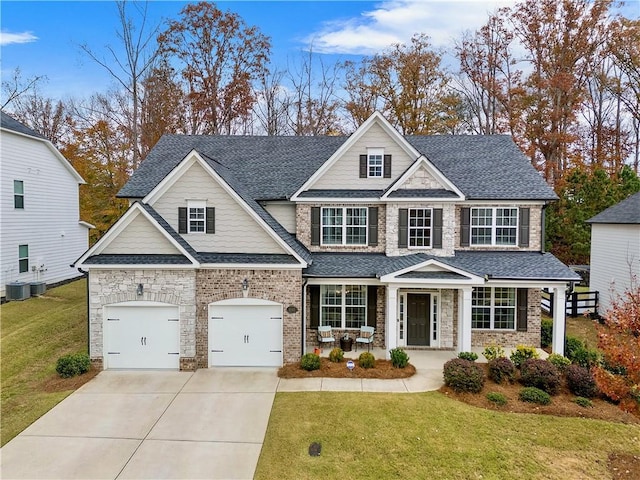 craftsman house with a front yard, a porch, and a garage