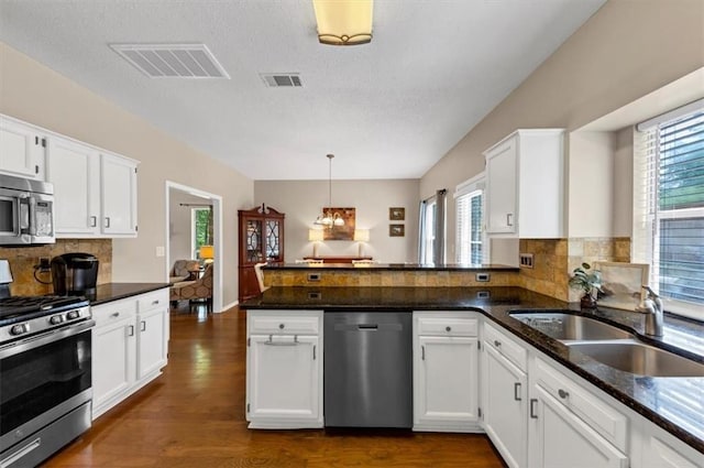 10535 Willow Meadow Cir, Alpharetta, GA 30022 - kitchen with stainless steel appliances, a peninsula, white cabinets, and a textured ceiling