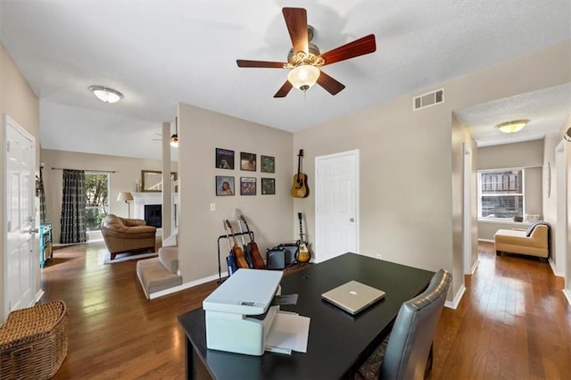 10535 Willow Meadow Cir, Alpharetta, GA 30022 - dining space with dark wood-style flooring, ceiling fan, and a glass covered fireplace
