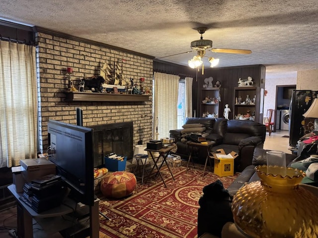 living room with a textured ceiling, ceiling fan, and a fireplace