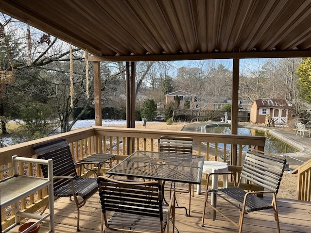 wooden terrace featuring a water view and a storage unit