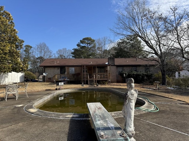 back of house with a wooden deck and a patio