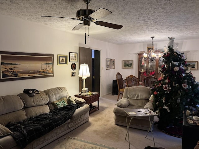 living room featuring ceiling fan with notable chandelier, light colored carpet, and a textured ceiling