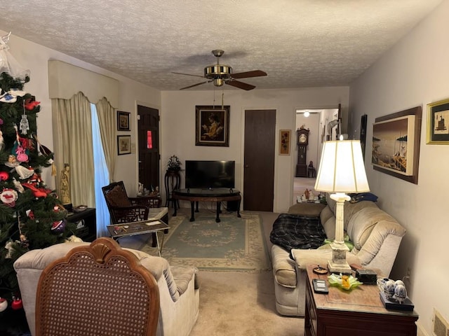 living room featuring a textured ceiling, ceiling fan, and light carpet