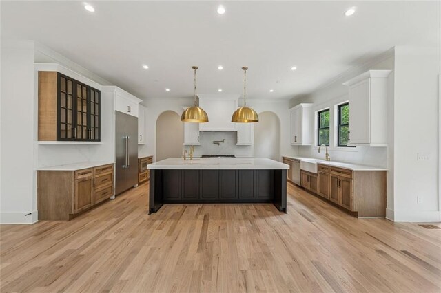 2797 Benson Dr, Marietta, GA 30062 - kitchen with high end fridge, a sink, light countertops, an island with sink, and light wood-style flooring