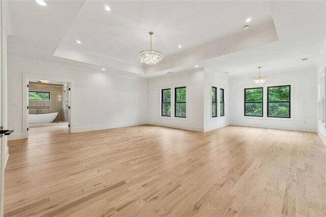 2797 Benson Dr, Marietta, GA 30062 - unfurnished living room with a chandelier, a tray ceiling, light wood finished floors, recessed lighting, and baseboards