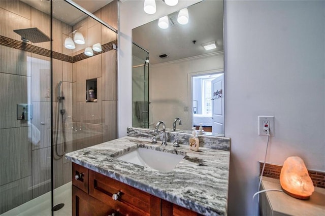 bathroom with a shower stall, visible vents, crown molding, and vanity